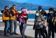 Los pasajeros llegan al puerto de Corfú, en el noroeste de Grecia, luego de ser evacuados de un ferry el viernes 18 de febrero de 2022.  Más de 280 personas fueron evacuadas de un ferry en el noroeste de Grecia que se incendió durante la noche cuando se dirigía al sur de Italia, dijeron las autoridades.