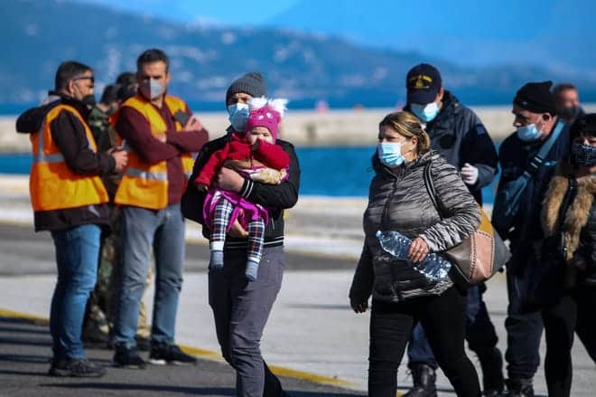 Los pasajeros llegan al puerto de Corfú, en el noroeste de Grecia, luego de ser evacuados de un ferry el viernes 18 de febrero de 2022.  Más de 280 personas fueron evacuadas de un ferry en el noroeste de Grecia que se incendió durante la noche cuando se dirigía al sur de Italia, dijeron las autoridades.