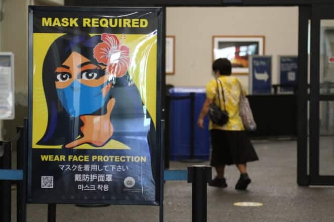 En esta foto de archivo del 2 de octubre de 2020, un letrero en el Aeropuerto Internacional de Honolulu hace cumplir las reglas de mascarillas en interiores de Hawái.