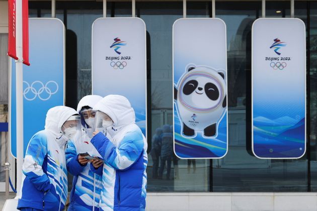 Voluntarios para los Juegos Olímpicos de Invierno de Beijing frente al Centro Acuático Nacional de Beijing...