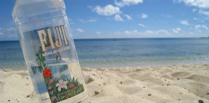 Una botella de agua de Fiji en la playa
