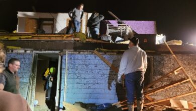 Las personas sacan sus pertenencias de sus hogares después de que un tornado arrasara el 5 de marzo de 2022 en Winterset, Iowa.