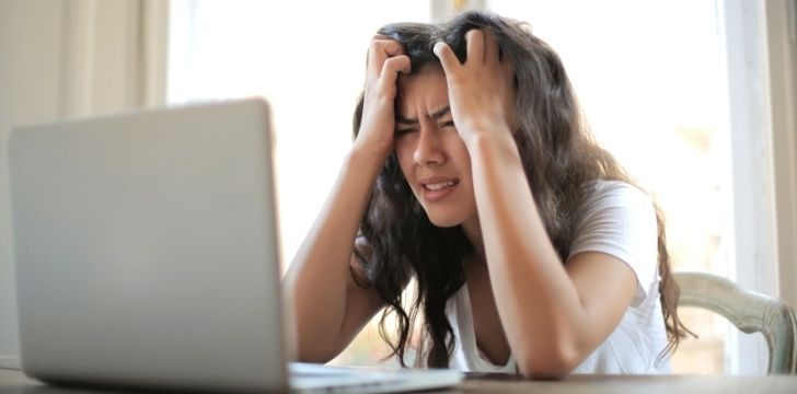 Una mujer está frustrada con su computadora portátil