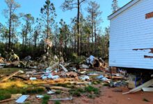 Los escombros cuelgan de los árboles fuera de la casa rodante cuando el tornado golpea Wancliffe, Mississippi.