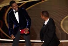 Presenter Chris Rock, left, reacts after being hit on stage by Will Smith while presenting the award for best documentary feature at the Oscars on Sunday, March 27, 2022, at the Dolby Theatre in Los Angeles. (AP Photo/Chris Pizzello)
