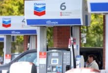 Un cliente habla por teléfono mientras espera que su auto se llene en una gasolinera Chevron el 29 de abril de 2022 en Greenbrae, California.