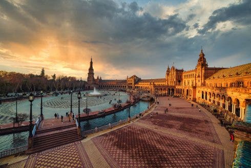 Escena dramática en la Plaza de España de Sevilla al atardecer