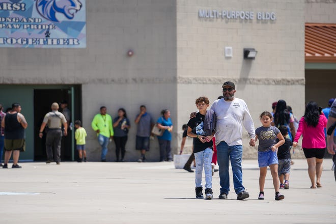 Una familia se aleja de la Escuela Primaria Thompson Ranch en El Mirage después de un cierre el 12 de agosto de 2022.