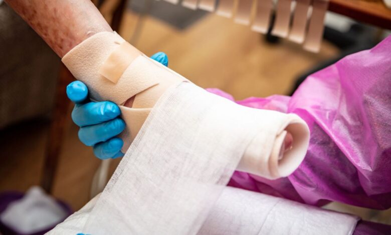 photo shows the gloved hands of a nurse wrapping a child