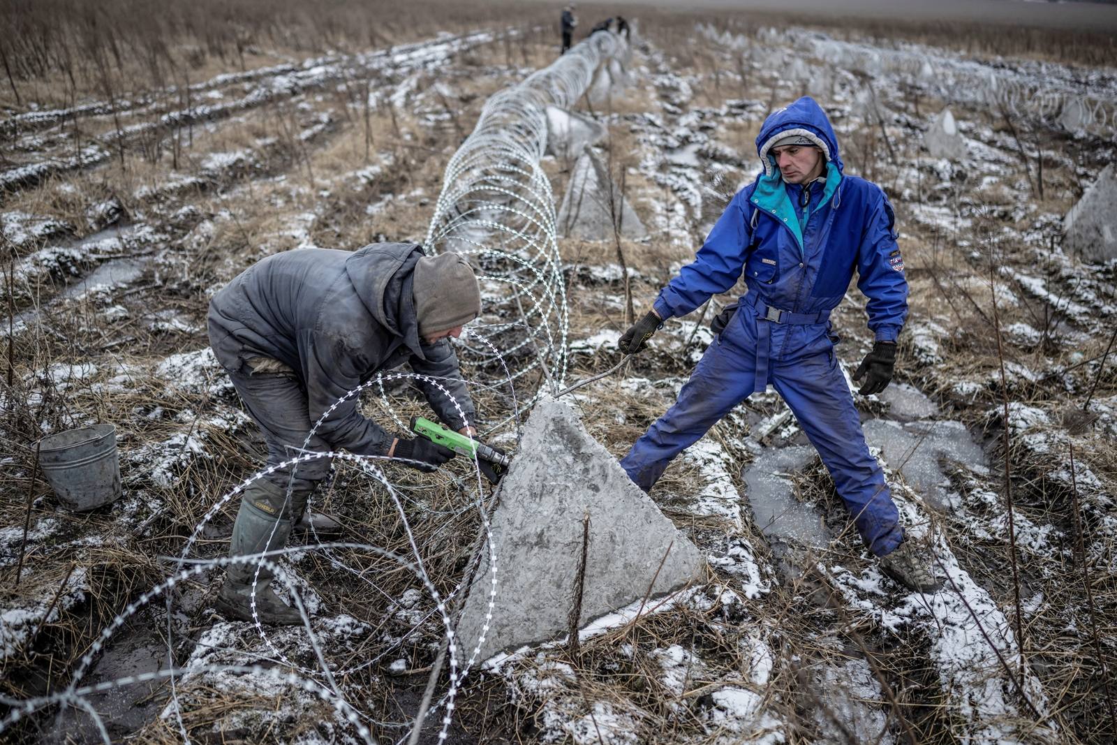 Los trabajadores instalan alambre de púas como parte de una estructura de defensa cerca de la línea del frente durante el ataque ruso a Ucrania en la región de Kharkiv de Ucrania el 25 de diciembre de 2023.  REUTERS/Viacheslav Ratynskyi