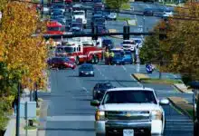 photo of a fire truck, ambulance and police vehicles blocking off traffic at an intersection where a crash appears to have taken place