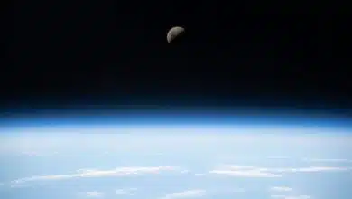 First quarter moon above earth in outer space.