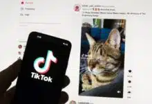 The TikTok logo is seen on a mobile phone in front of a computer screen which displays the TikTok home screen, Saturday, March 18, 2023, in Boston. European Union regulators said Wednesday, April 17, 2024, they’re seeking details from TikTok on a new app from the video sharing platform that pays users to watch videos.
